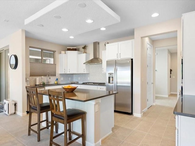 5220 Gold Hill Ln, Santa Fe, NM 87507 - kitchen with stainless steel appliances, wall chimney range hood, dark countertops, backsplash, and a kitchen bar
