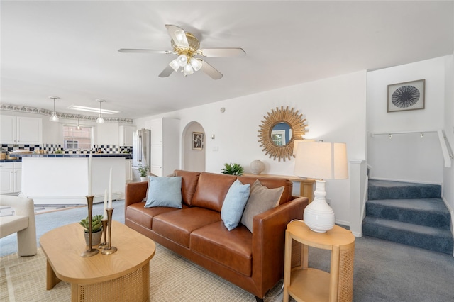 917 Estates Dr, Los Alamos, NM 87544 - living area with light colored carpet, arched walkways, ceiling fan, and stairs