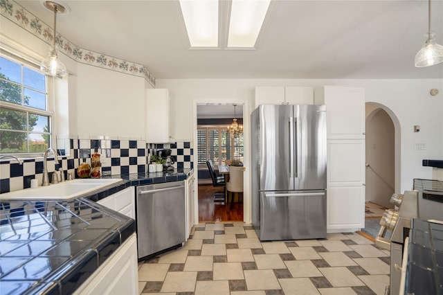 917 Estates Dr, Los Alamos, NM 87544 - kitchen with appliances with stainless steel finishes, tile countertops, a sink, white cabinetry, and backsplash