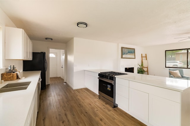1180 Sioux, Los Alamos, NM 87544 - kitchen featuring gas stove, a peninsula, light countertops, white cabinets, and wood finished floors