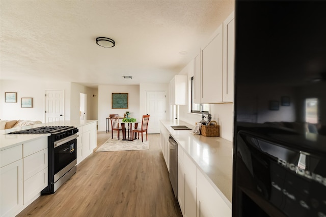 1180 Sioux, Los Alamos, NM 87544 - kitchen featuring stainless steel appliances, white cabinets, light countertops, light wood-style flooring, and a textured ceiling