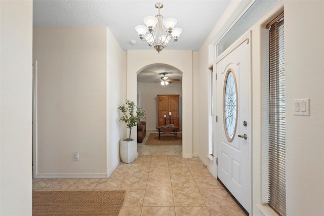 1810 Eucalyptus Rd NE, Rio Rancho, NM 87144 - foyer entrance with a chandelier, arched walkways, ceiling fan, baseboards, and light tile patterned floors