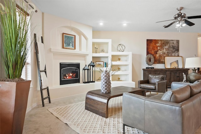 1810 Eucalyptus Rd NE, Rio Rancho, NM 87144 - carpeted living room featuring a ceiling fan, a glass covered fireplace, built in shelves, baseboards, and recessed lighting