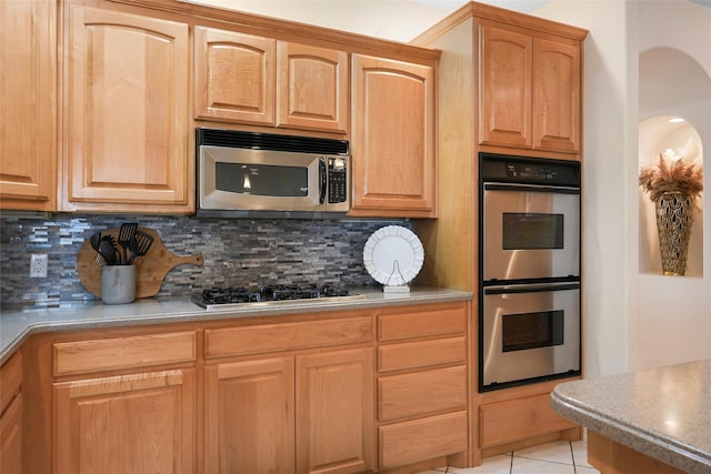 1810 Eucalyptus Rd NE, Rio Rancho, NM 87144 - kitchen featuring appliances with stainless steel finishes, backsplash, light tile patterned floors, arched walkways, and light brown cabinets