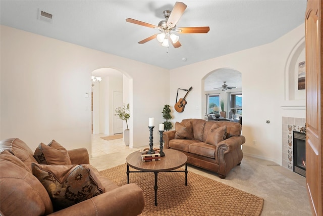 1810 Eucalyptus Rd NE, Rio Rancho, NM 87144 - living room with arched walkways, a ceiling fan, a tile fireplace, and light colored carpet