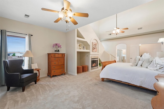 1810 Eucalyptus Rd NE, Rio Rancho, NM 87144 - bedroom featuring a tiled fireplace, carpet flooring, arched walkways, baseboards, and ceiling fan