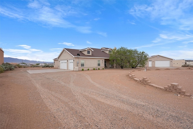 1810 Eucalyptus Rd NE, Rio Rancho, NM 87144 - view of front of house with driveway, stucco siding, a mountain view, and a garage