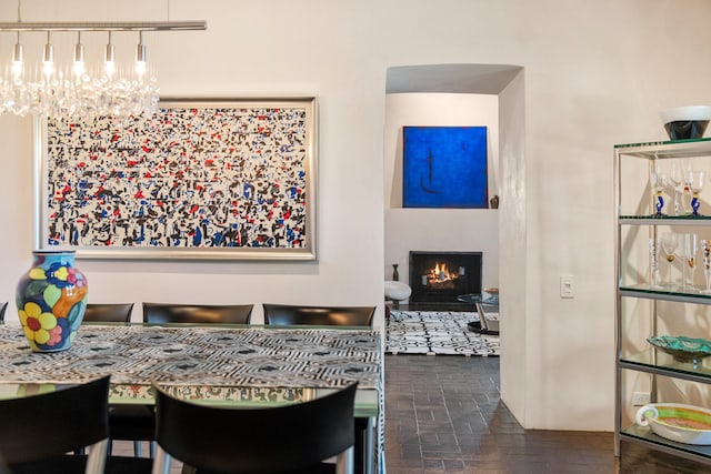 519 E Palace Ave, Santa Fe, NM 87501 - dining room featuring a chandelier, a fireplace with flush hearth, and brick patterned floors