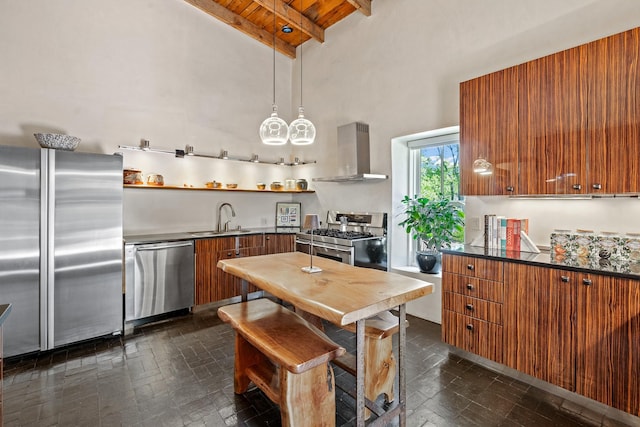 519 E Palace Ave, Santa Fe, NM 87501 - kitchen featuring wall chimney range hood, stainless steel appliances, brown cabinets, a sink, and dark countertops