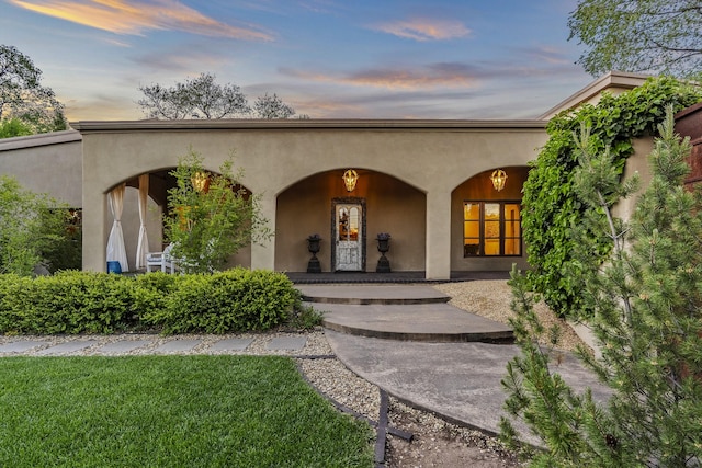 519 E Palace Ave, Santa Fe, NM 87501 - entrance to property featuring a porch, stucco siding, and a lawn