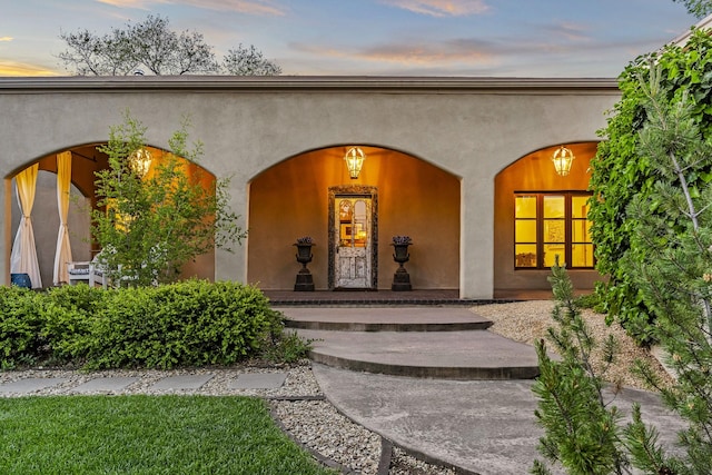 519 E Palace Ave, Santa Fe, NM 87501 - exterior entry at dusk featuring covered porch and stucco siding