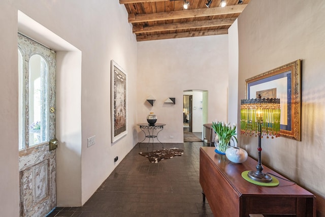 519 E Palace Ave, Santa Fe, NM 87501 - foyer entrance with wood ceiling with exposed beams, arched walkways, a high ceiling, and brick patterned floors
