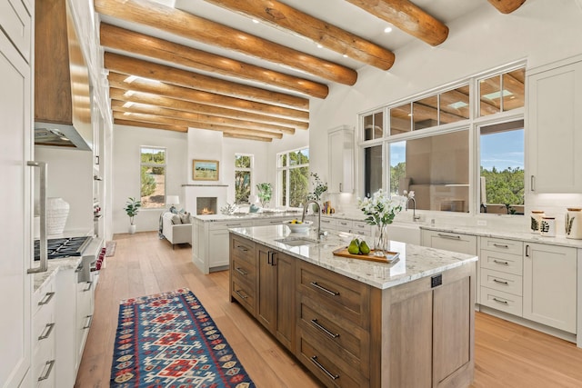 6 Sierra Ct, Santa Fe, NM 87506 - kitchen with a sink, light wood-style flooring, beamed ceiling, stainless steel gas stovetop, and white cabinetry