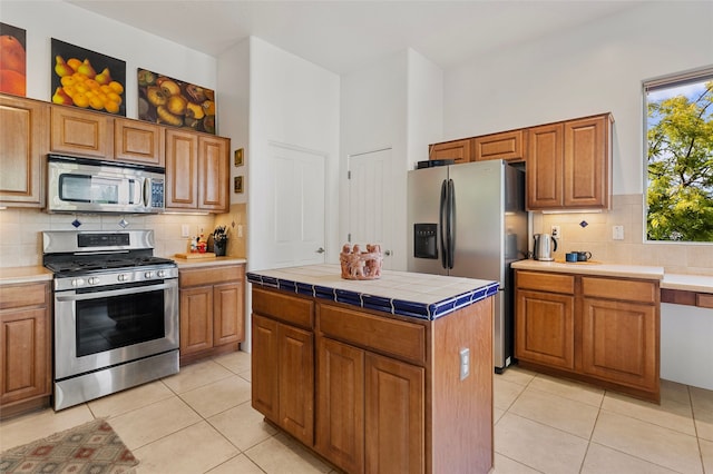 1 Pajarito Peak, Santa Fe, NM 87508 - kitchen with appliances with stainless steel finishes, light tile patterned floors, tasteful backsplash, and tile counters