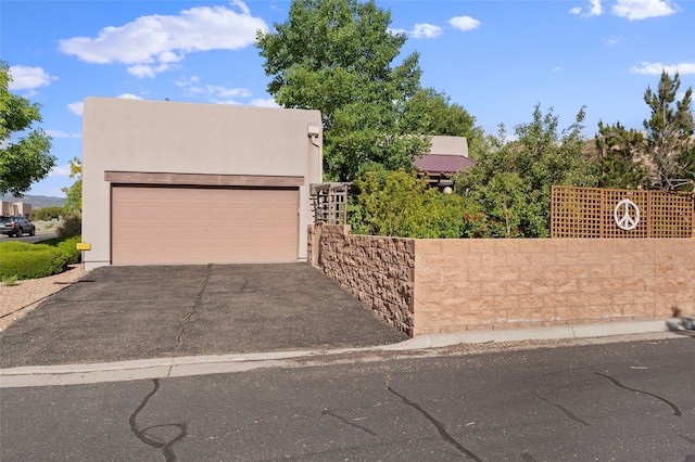 1 Pajarito Peak, Santa Fe, NM 87508 - view of front of house with a garage and stucco siding