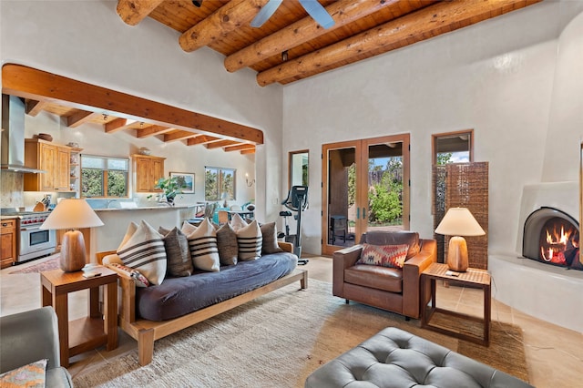 557 Valle Chamiso Ln, Santa Fe, NM 87505 - living area featuring wooden ceiling with exposed beams, a towering ceiling, a large fireplace, light tile patterned flooring, and a ceiling fan