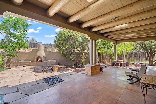 557 Valle Chamiso Ln, Santa Fe, NM 87505 - fenced backyard featuring a patio area and a lit fireplace