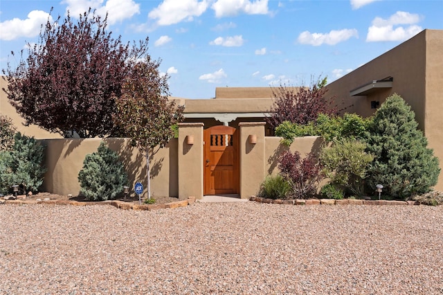 557 Valle Chamiso Ln, Santa Fe, NM 87505 - pueblo-style home featuring stucco siding and a gate
