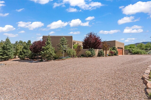 557 Valle Chamiso Ln, Santa Fe, NM 87505 - view of yard with gravel driveway and an attached garage