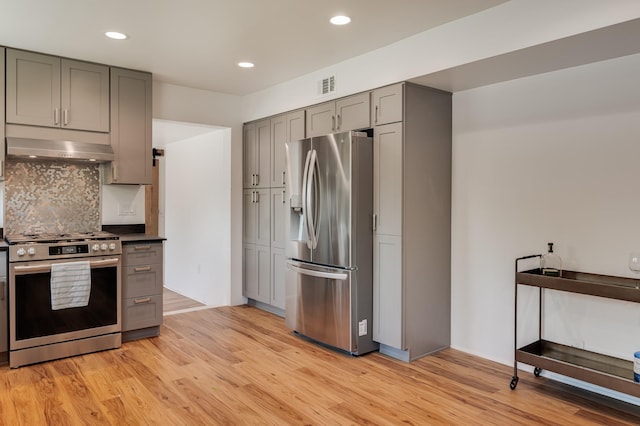 202 Alamo Dr, Santa Fe, NM 87501 - kitchen featuring appliances with stainless steel finishes, extractor fan, gray cabinetry, light wood-style floors, and recessed lighting