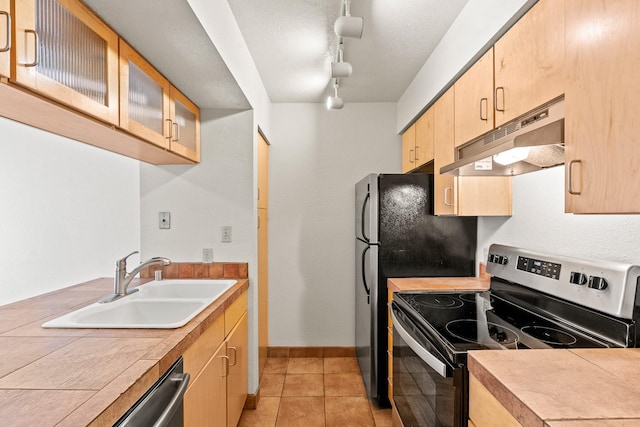 941 Calle Mejia Unit 1610, Santa Fe, NM 87501 - kitchen featuring stainless steel appliances, a sink, under cabinet range hood, light brown cabinetry, and light tile patterned floors