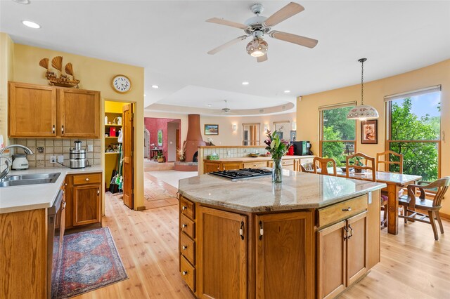 65 E Sombrillo Rd, Nm, NM 87532 - kitchen with a sink, a ceiling fan, light wood-type flooring, backsplash, and stainless steel gas cooktop