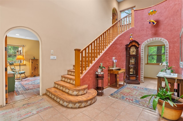 65 E Sombrillo Rd, Nm, NM 87532 - staircase with arched walkways, a high ceiling, and tile patterned floors