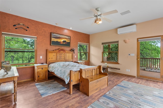 65 E Sombrillo Rd, Nm, NM 87532 - bedroom with a wall mounted air conditioner, access to exterior, multiple windows, and light wood-type flooring