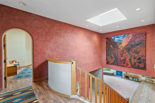 65 E Sombrillo Rd, Nm, NM 87532 - corridor featuring a skylight, wood-type flooring, arched walkways, recessed lighting, and an upstairs landing