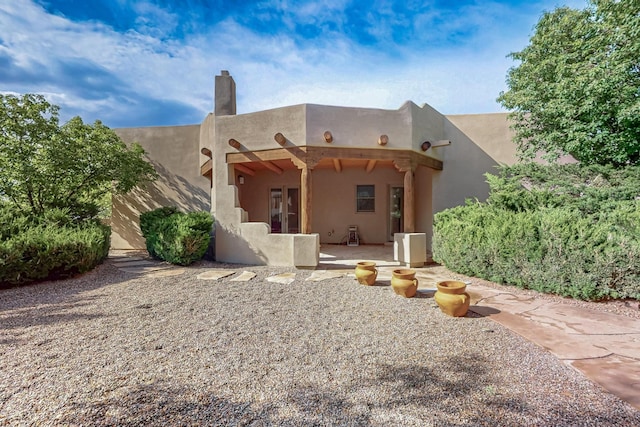 138 E Chili Line, Santa Fe, NM 87508 - back of house featuring a chimney and a patio