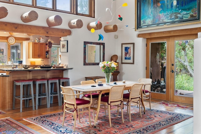 525 Camino Militar, Santa Fe, NM 87501 - dining area featuring wood finished floors, a towering ceiling, and french doors