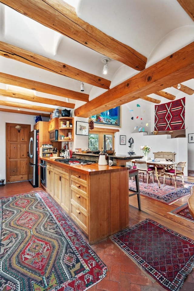 525 Camino Militar, Santa Fe, NM 87501 - kitchen with appliances with stainless steel finishes, open shelves, butcher block counters, and beamed ceiling