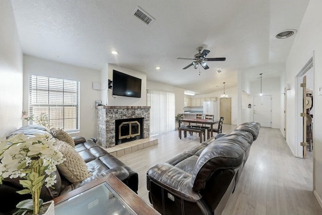 1128 Pandora Dr SW, Los Lunas, NM 87031 - living area featuring plenty of natural light, ceiling fan, light wood-style floors, a tiled fireplace, and recessed lighting