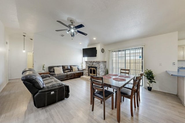 1128 Pandora Dr SW, Los Lunas, NM 87031 - dining area featuring a fireplace, ceiling fan, and light wood-style flooring