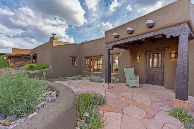 26 Camino Los Angelitos, Santa Fe, NM 87540 - entrance to property with a patio and a chimney