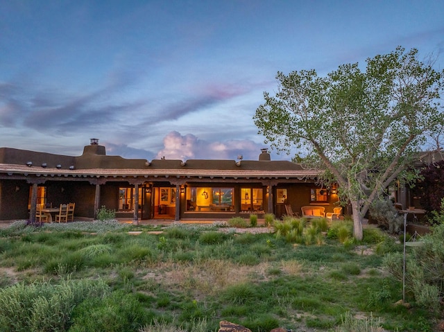 26 Camino Los Angelitos, Santa Fe, NM 87540 - back of house at dusk with a chimney
