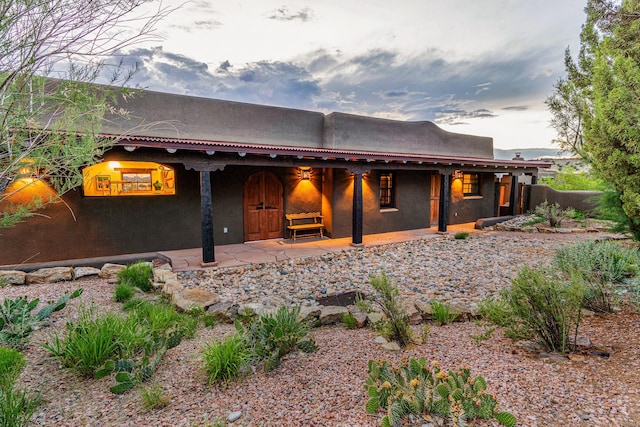 26 Camino Los Angelitos, Santa Fe, NM 87540 - rear view of property featuring stucco siding and covered porch