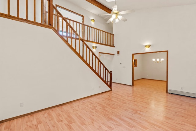 1327 San Ildefonso Rd, Los Alamos, NM 87544 - unfurnished living room featuring stairs, wood finished floors, ceiling fan, a chandelier, and a towering ceiling