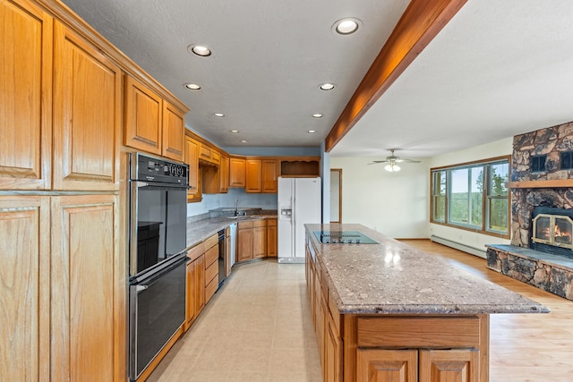 1327 San Ildefonso Rd, Los Alamos, NM 87544 - kitchen with black appliances, a baseboard radiator, a center island, light stone counters, and recessed lighting