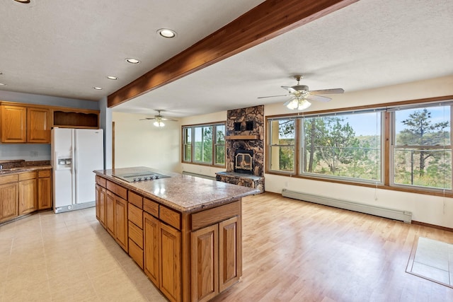 1327 San Ildefonso Rd, Los Alamos, NM 87544 - kitchen with white refrigerator with ice dispenser, a baseboard radiator, a kitchen island, brown cabinetry, and a ceiling fan