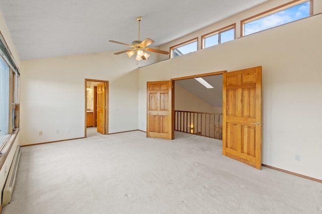 1327 San Ildefonso Rd, Los Alamos, NM 87544 - unfurnished living room featuring ceiling fan, a baseboard radiator, light colored carpet, baseboards, and high vaulted ceiling