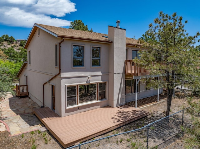 1327 San Ildefonso Rd, Los Alamos, NM 87544 - back of house featuring a chimney, a wooden deck, stucco siding, and a patio