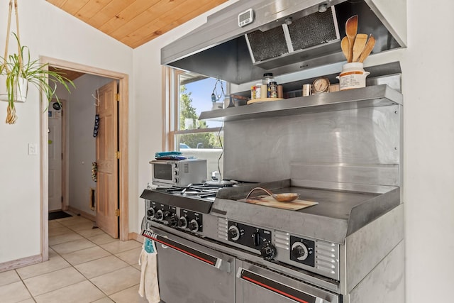 71 Apache Plume Dr, Santa Fe, NM 87508 - kitchen with wall chimney range hood, light tile patterned floors, lofted ceiling, wood ceiling, and baseboards