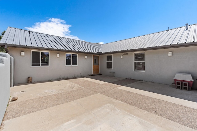 71 Apache Plume Dr, Santa Fe, NM 87508 - rear view of house with stucco siding, metal roof, and a patio area