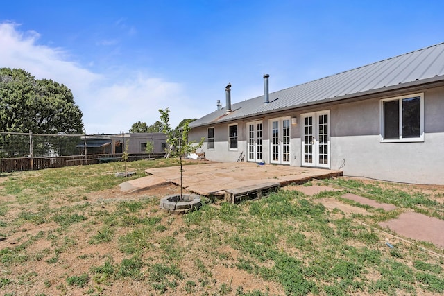 71 Apache Plume Dr, Santa Fe, NM 87508 - rear view of property with french doors, stucco siding, and metal roof