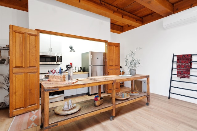 749 Alto St Unit A, Santa Fe, NM 87501 - kitchen with appliances with stainless steel finishes, a wall mounted air conditioner, wood ceiling with exposed beams, light wood-style flooring, and light countertops