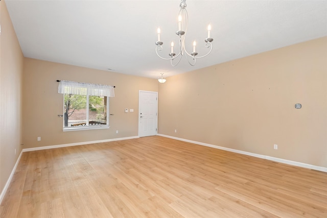2613 Camino Catalonia, Rio Rancho, NM 87124 - empty room featuring light wood finished floors, a chandelier, and baseboards