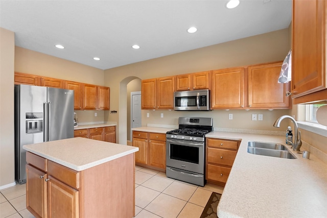 2613 Camino Catalonia, Rio Rancho, NM 87124 - kitchen with stainless steel appliances, a sink, light tile patterned floors, light countertops, and arched walkways