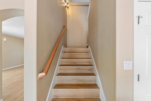 2613 Camino Catalonia, Rio Rancho, NM 87124 - stairs featuring arched walkways, wood finished floors, and baseboards