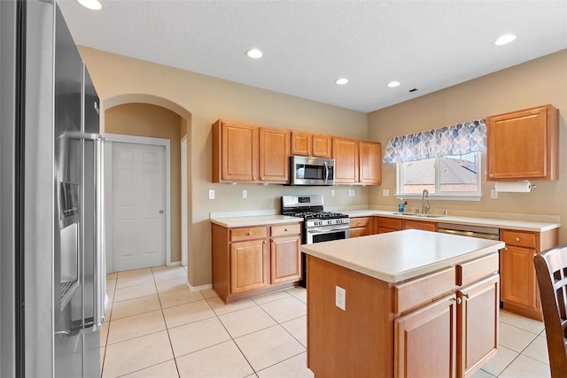 2613 Camino Catalonia, Rio Rancho, NM 87124 - kitchen with stainless steel appliances, a sink, light countertops, arched walkways, and recessed lighting